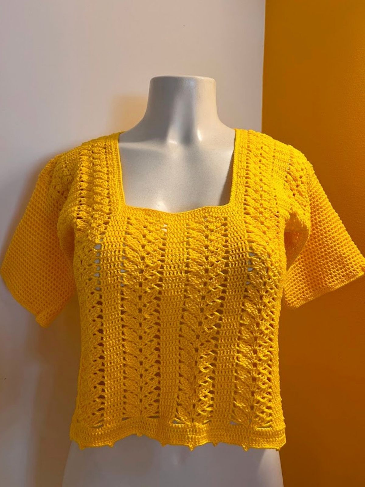 Blusa Clarice 4 Blusa Clarice de Crochê amarela com decote quadrado, trama vertical e manga curta tradicional vestida no manequim