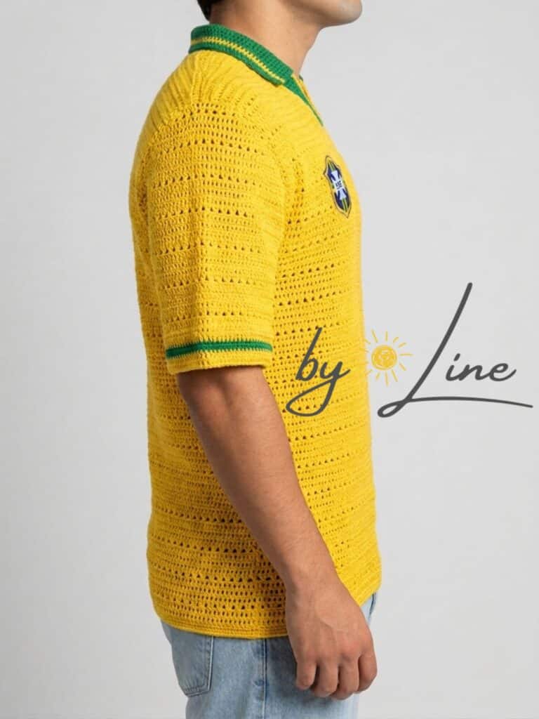 Modelo a vestir a peça finalizada da Receita Camisa Retrô Brasil 1994 em Crochê, a evidenciar o caimento desportivo da blusa e as listras subtis nas mangas. Receita Camisa Retro Brasil 1994 de Crochê