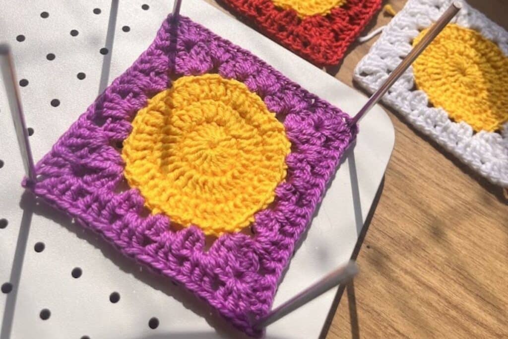 Square emoji de croche posicionado na placa de blocagem com alfinetes para alinhamento