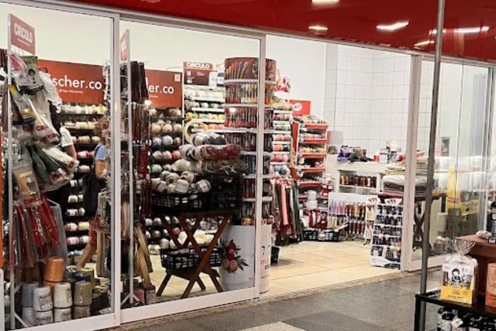 Entrada da loja de crochê Zezinho Armarinho na Galeria 346 da Tijuca no Rio de Janeiro com prateleiras de linhas e fios